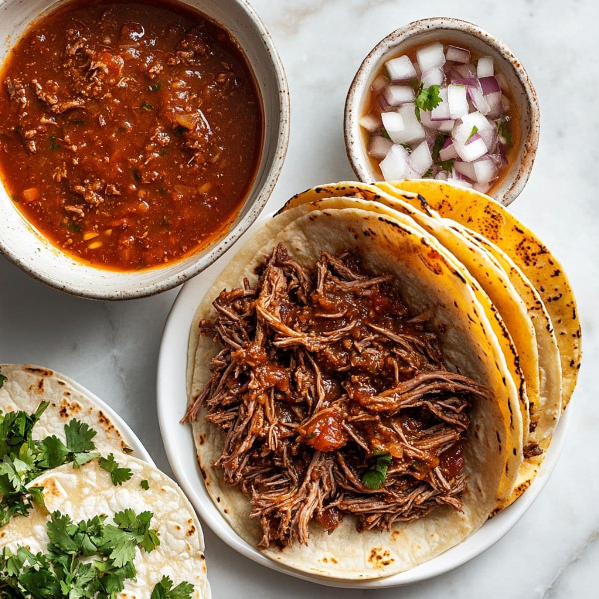 assemble the tacos for birria tacos recipe with cheese and shredded beef