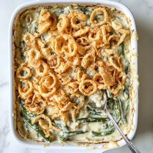 layer and season green bean casserole recipe with fried onions and spices in a baking dish