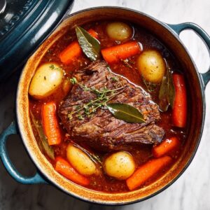 long slow braise for pot roast recipe with beef, carrots, and potatoes simmering in broth