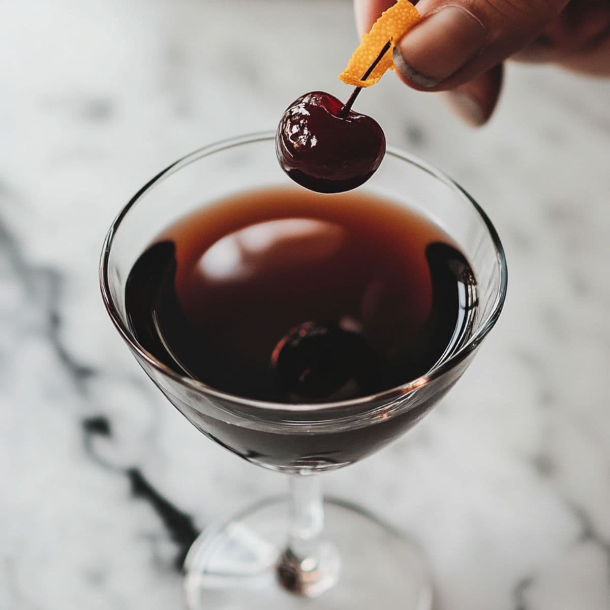 straining and garnishing black manhattan recipe