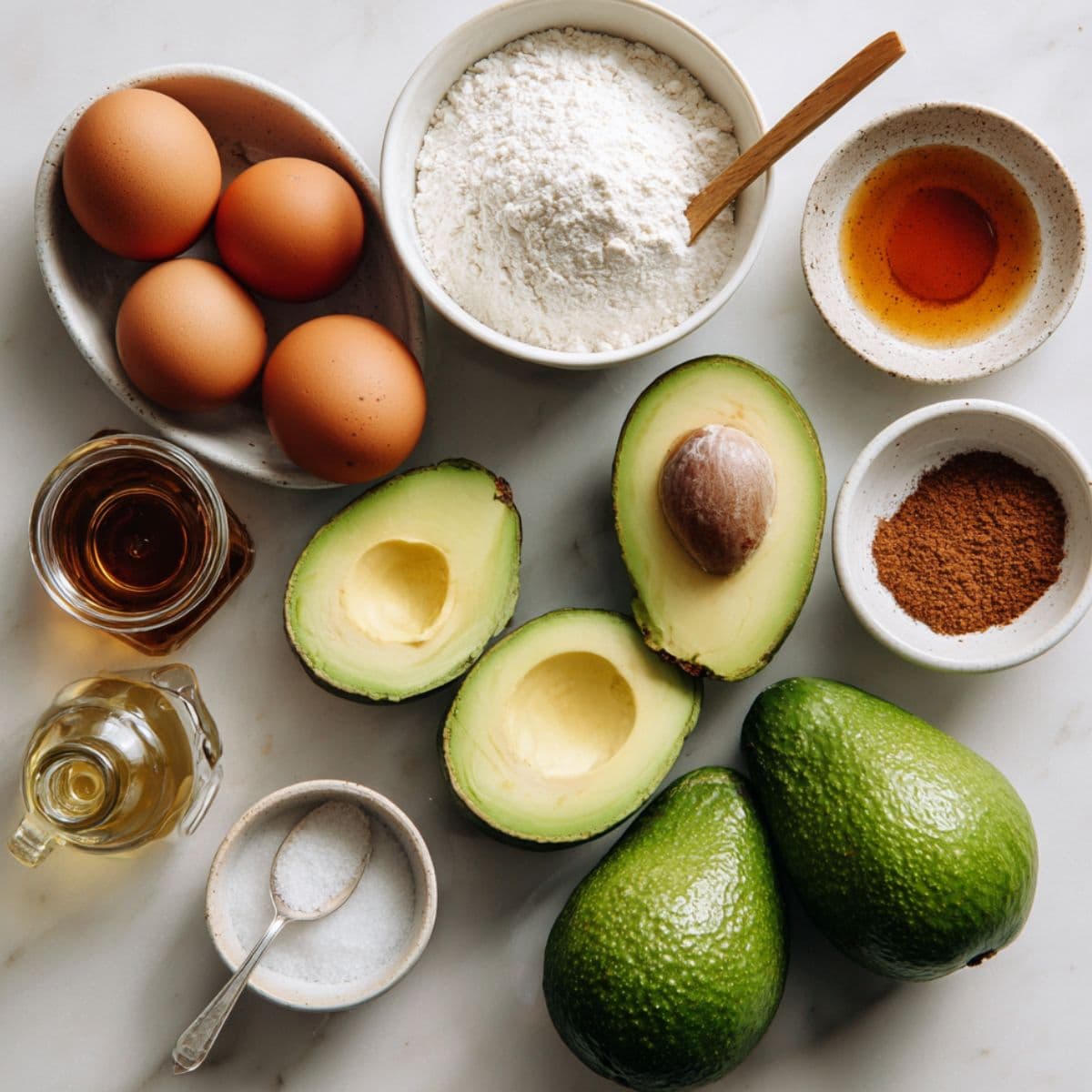 main ingredients for avocado bread recipe laid out on white marble