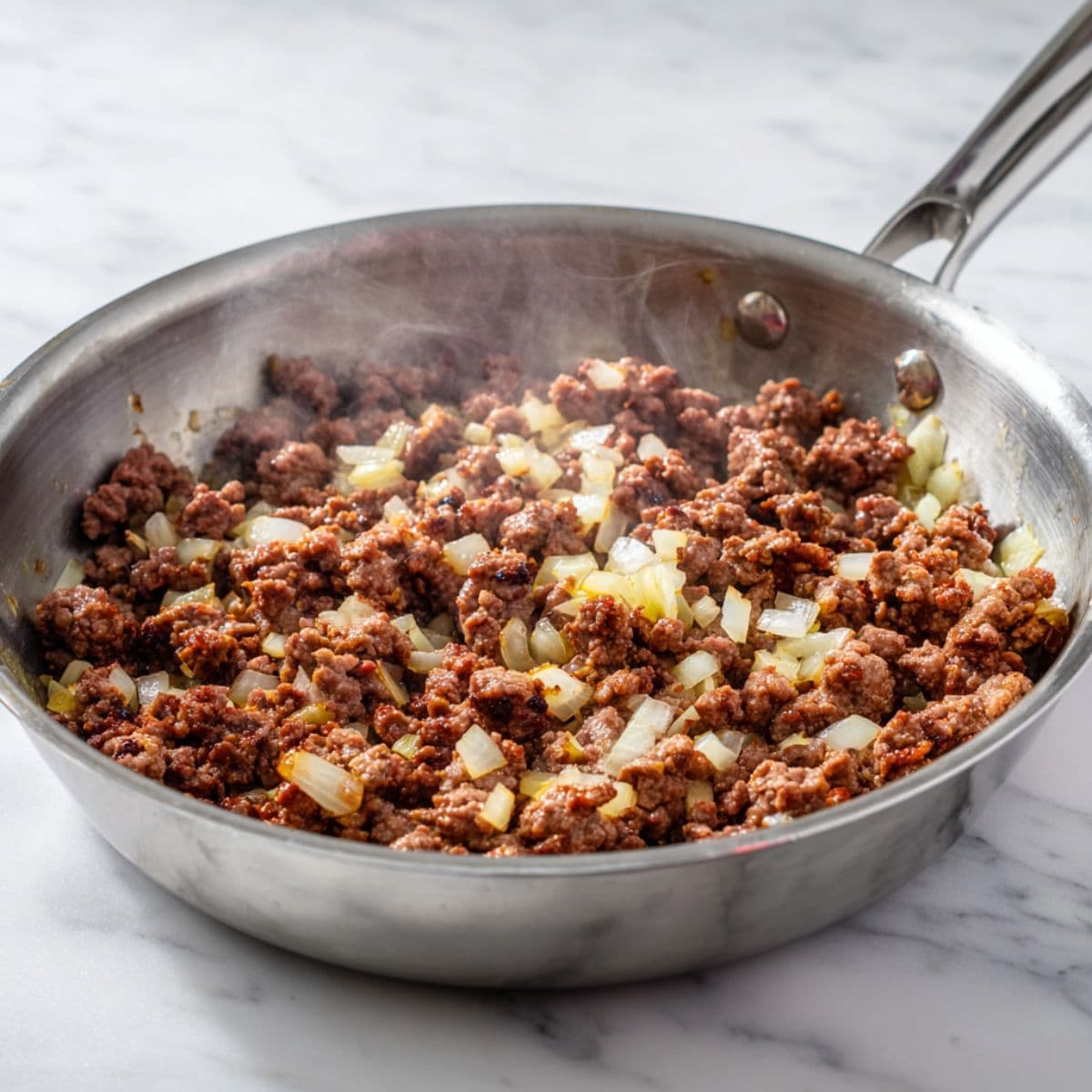 brown the meat for rotel dip recipe with ground beef, garlic, and onion cooking in a pot