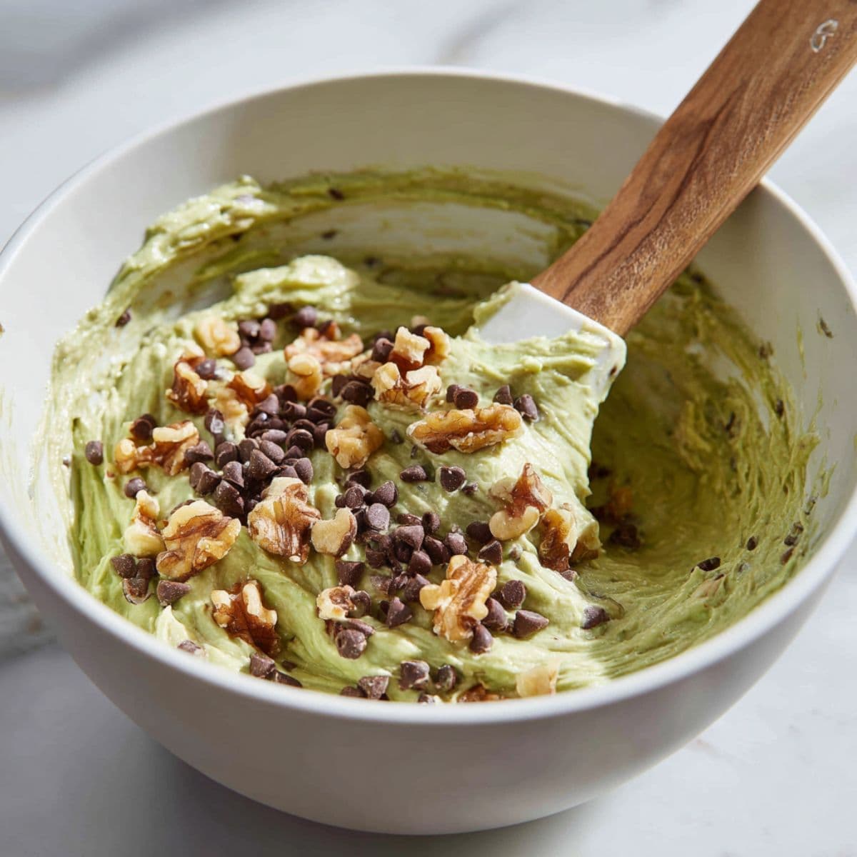 avocado bread batter being folded gently with chocolate chips