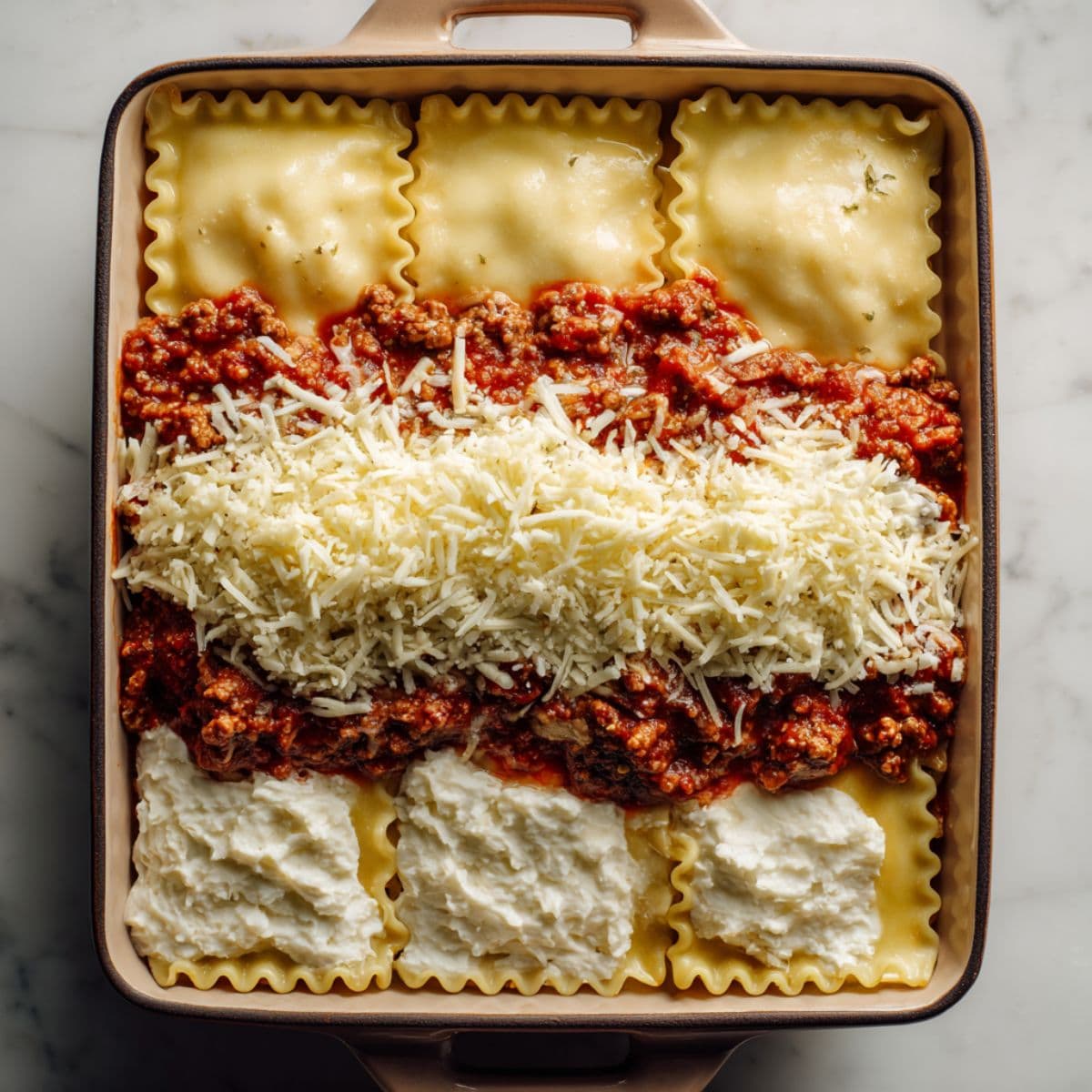 layering noodles ricotta meat sauce and cheese for lasagna recipe