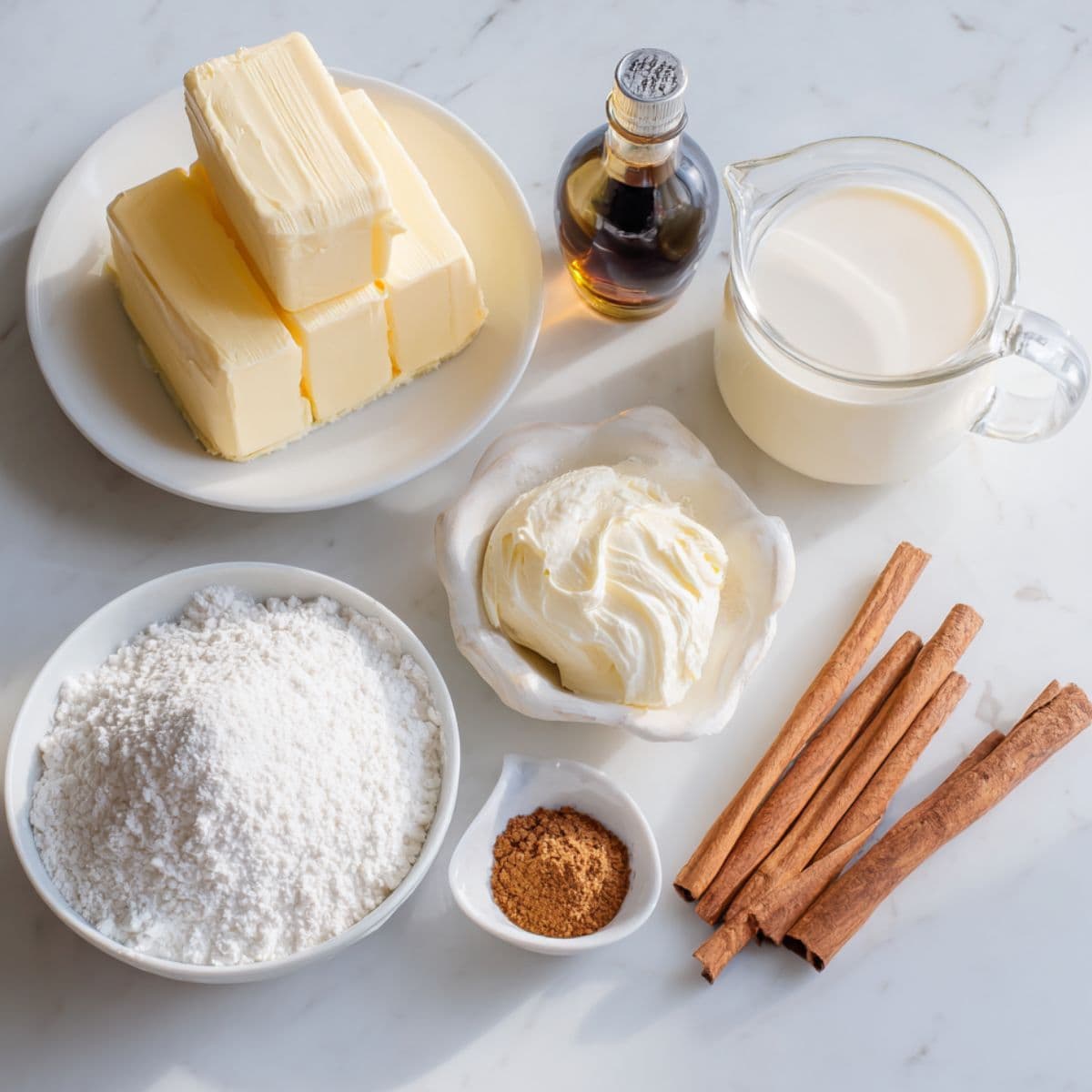 flat lay of butter pecan cake frosting ingredients including butter, cream cheese, powdered sugar, vanilla, and heavy cream