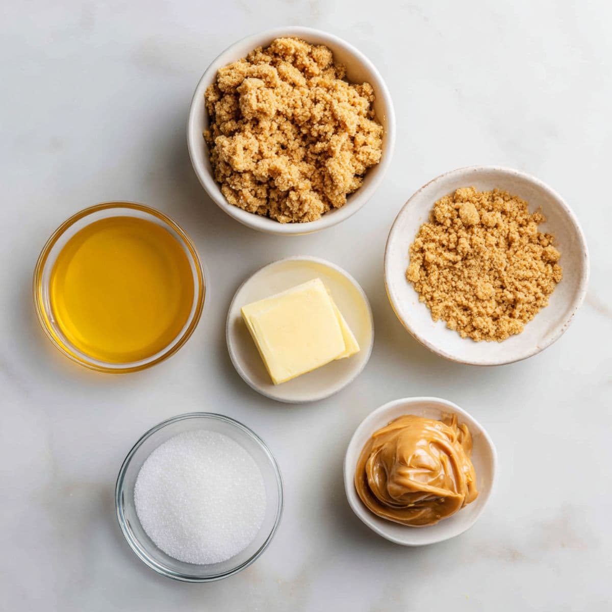 graham cracker crumbs, sugar, melted butter, and salt arranged neatly on white marble