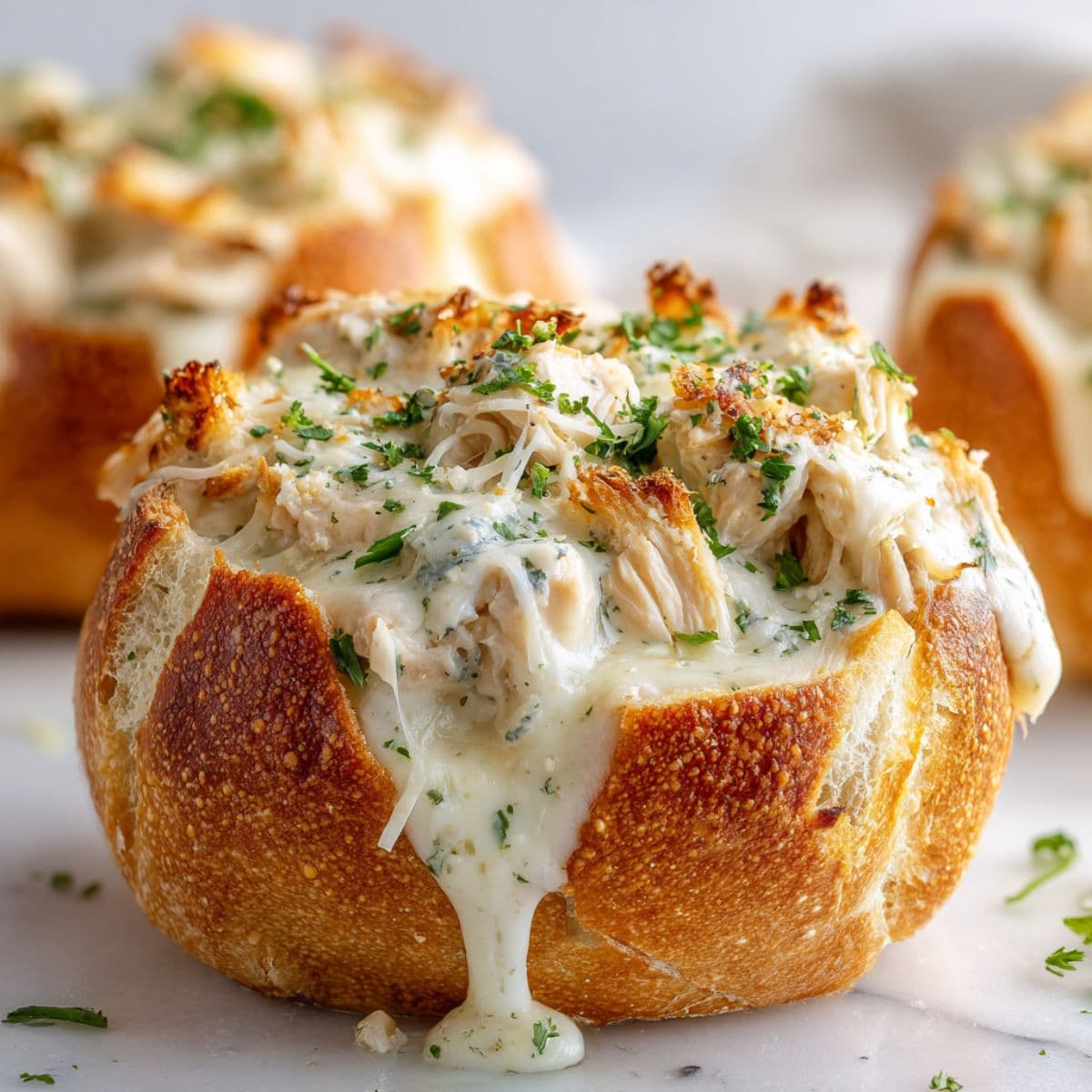 preparing chicken alfredo garlic bread bowls