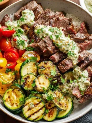 grilled steak bowl with creamy sauce and zucchini