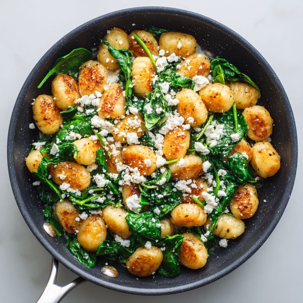 tossing gnocchi with spinach and feta